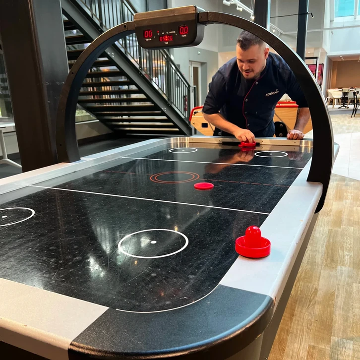 Table de air hockey noire dans un espace de loisirs intérieur moderne