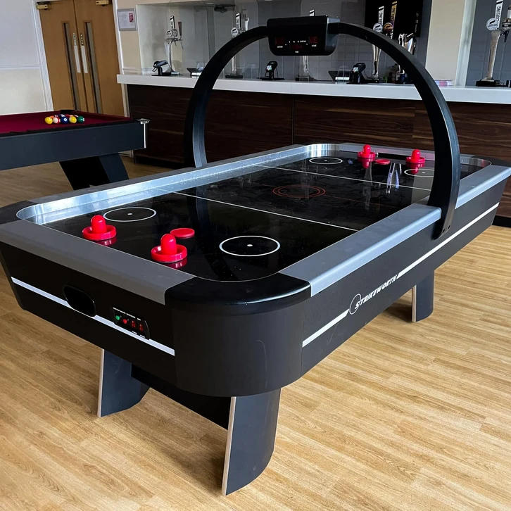 Intérieur d'un magasin d'électronique moderne avec rayonnages blancs présentant consoles de jeux vidéo, accessoires gaming et ordinateurs portables