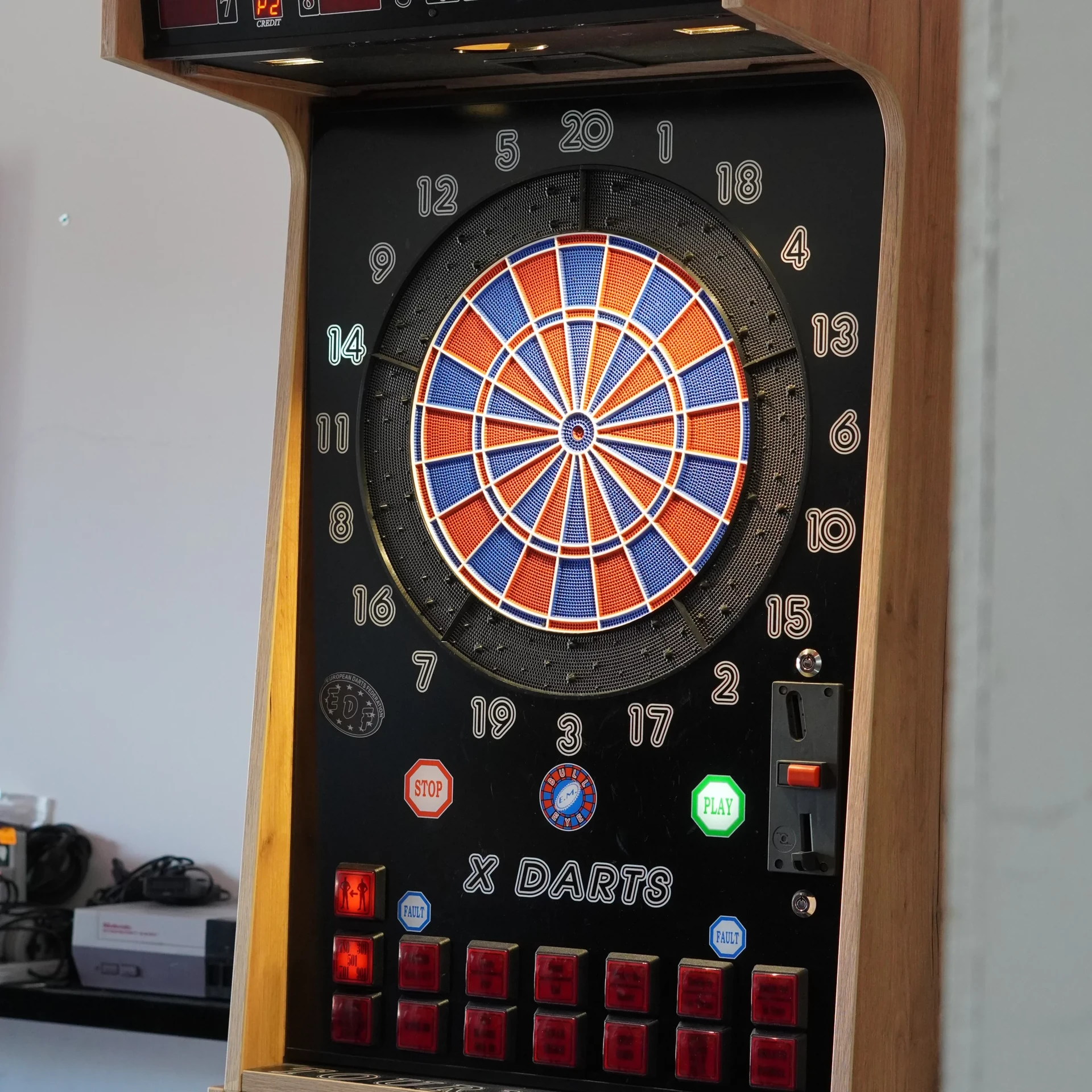Salle de jeux résidentielle avec baby-foot au premier plan, panier de basketball mural, télévision écran plat et mobilier de bar
